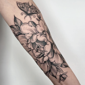 Black and grey tattoo of a peony flower with a butterfly