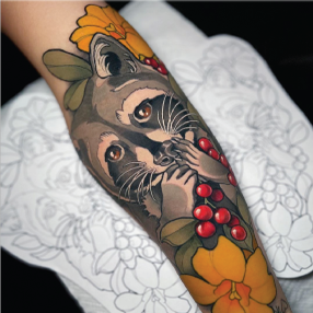 Neo traditional tattoo of a grey raccoon eating red berries surrounded by green leaves and yellow flowers