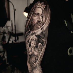 Black ink realism tattoo of a male portrait wearing a crown above a baby angel