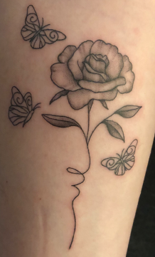 black and grey flower tattoo with three butterflies surrounding it